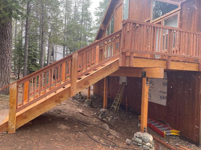 New cedar staircase and railing descending from an elevated cabin deck