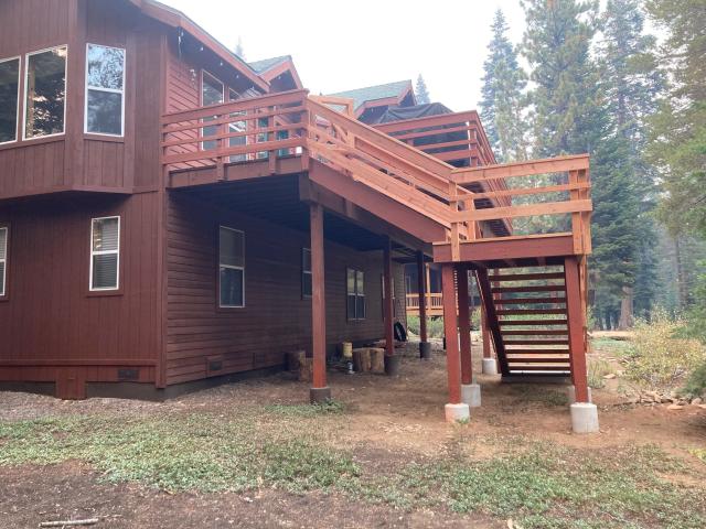 Elevated second-story deck and stairway supported on posts with concrete pier footings