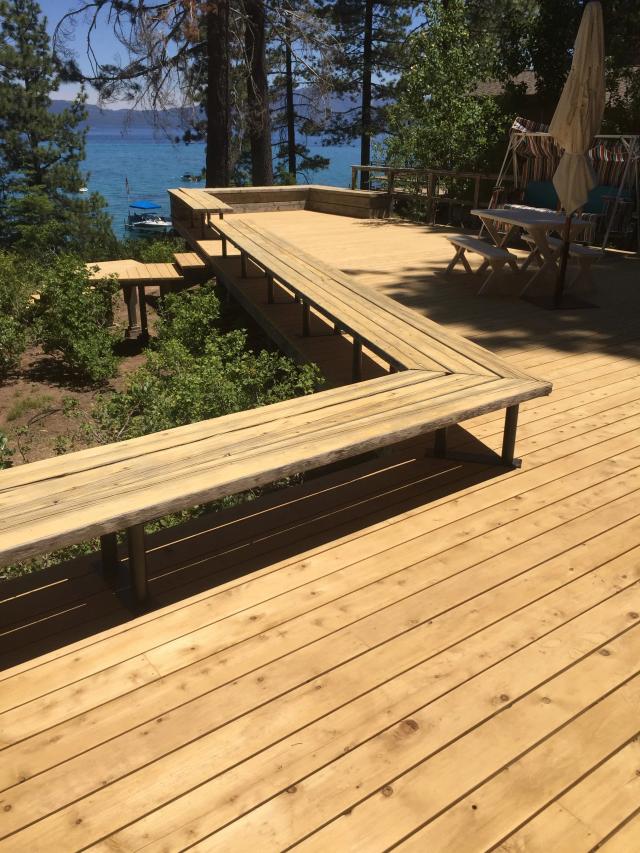 Wraparound built-in bench framing a lakefront cedar deck above Lake Tahoe