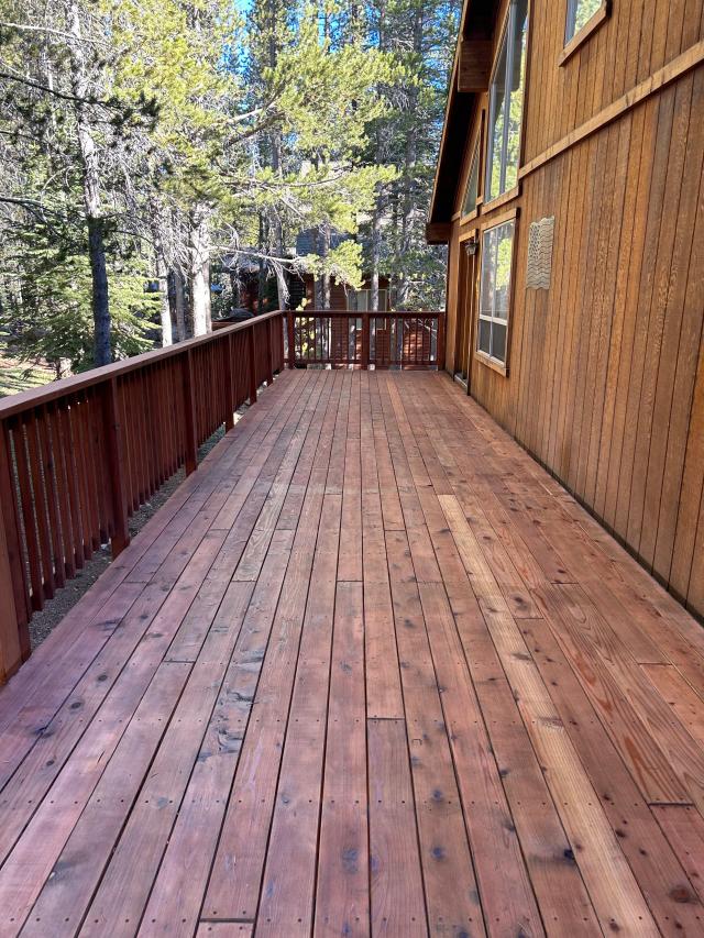 Long redwood-toned deck wrapping a cedar-sided mountain cabin near Truckee